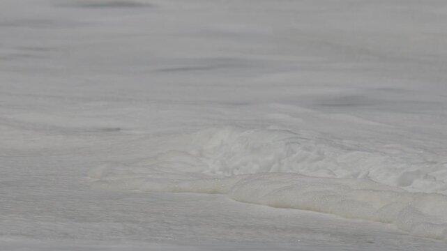 Close up of white frothy waves at the wedge