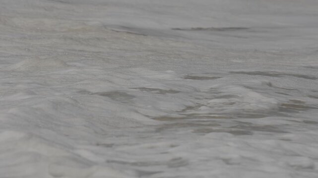 Close up of waves washing up on the sand