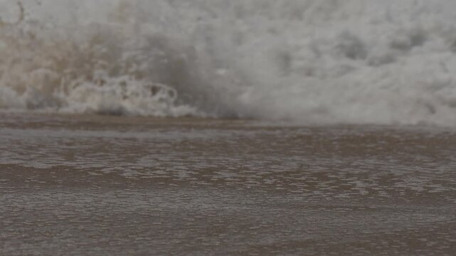 close up of waves washing up on the sand