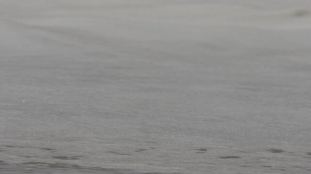 Close up of white frothy waves at the wedge