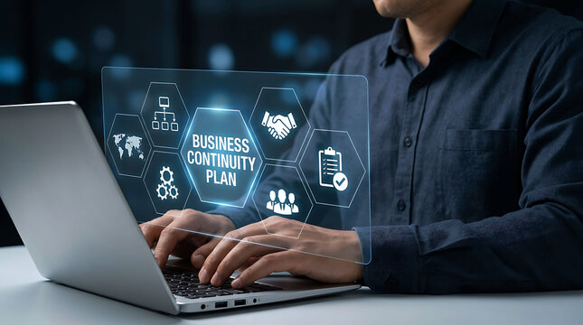 Businessman working on laptop with business continuity plan hologram text