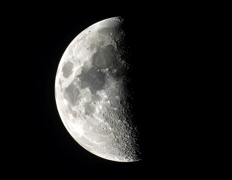 A bright gray moon with craters and shadows on a black background