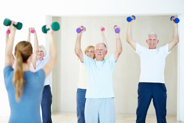 Fototapeta premium Weights, class and woman with senior people for exercise, wellness and stretching for mobility. Retirement, gym and trainer with elderly group with dumbbells for health, muscle strength and workout