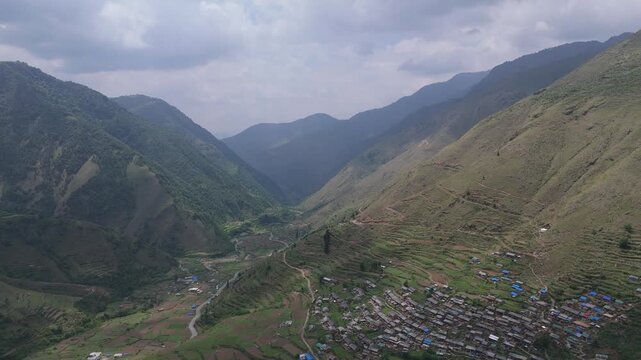High angle drone shot of switchback highway snaking along steep mountain ridge slopes under overcast sky