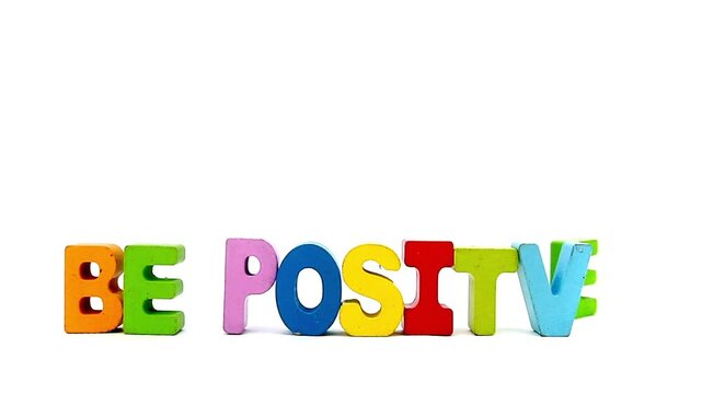 The words BE POSITIVE with painted wooden letters 