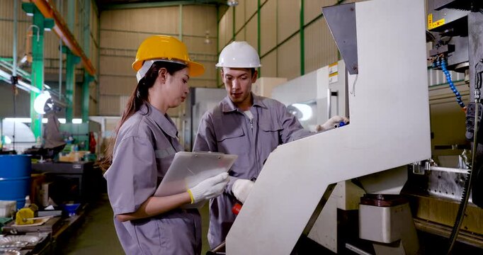 Asian engineer team checks machine panel with tablet, reviewing program data, operation status, safety step, maintenance task, production workflow coordination in , slow motion.