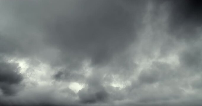 Dense, gray storm clouds move across the sky, indicating an approaching heavy rainstorm.