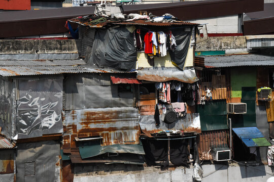 Slum shanty douses. Philippines poverty scene. Manila urban poor community. Houses with metal sheets as wall and roof. Clothes hanging by the window.