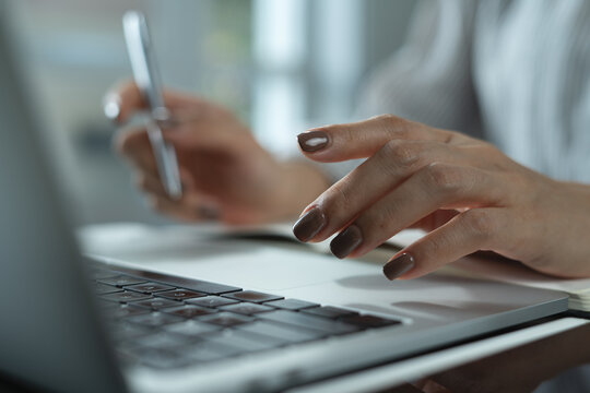 Close up of business woman working on laptop computer, surfing the internet, searching the information for business ideas, and project planning, corporate business concept