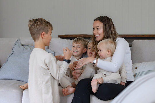 Young boys snuggling with mum on the couch