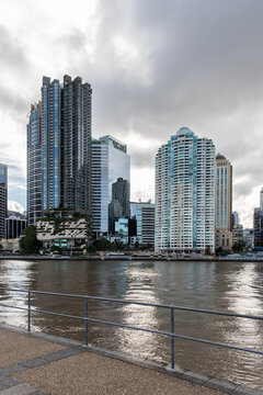 riverfront footpath with tall inner city buildings across the water