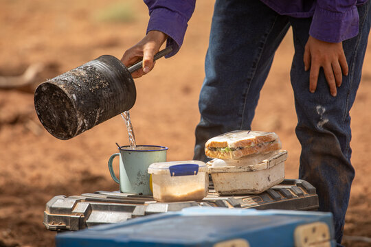 Pouring a cup of billy tea or coffee during dinner camp