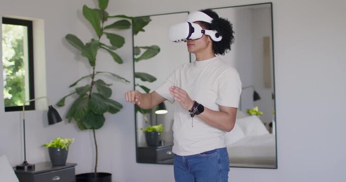 African American man gesturing with VR headset in bedroom, menu appearing, selecting UI elements