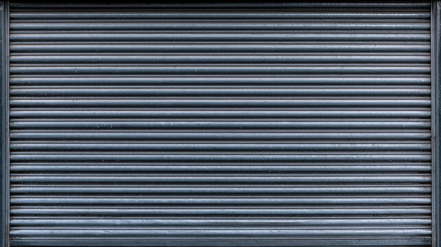 Closed store shutter metal shutter gray shutter roller door horizontal slat industrial texture weathered surface aluminum door close up copy space
