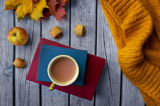 Autumn flatlay with cup of hot cocoa, books and apples on wooden table, cozy lifestyle, fall season, warm colors, home comfort, autumn mood, relaxation.