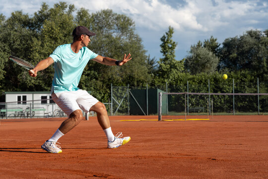 Professional tennis player preparing to return ball on clay court during match or training session. Focus, anticipation, athletic movement and competitive sports concept.