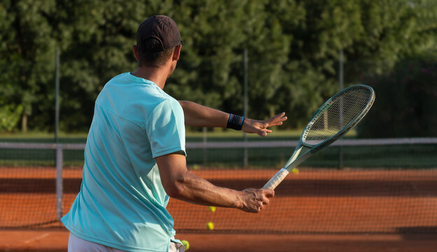 Professional tennis player performing forehand stroke on clay court during training session. Close-up view of technique, athletic movement, sports performance and active lifestyle.