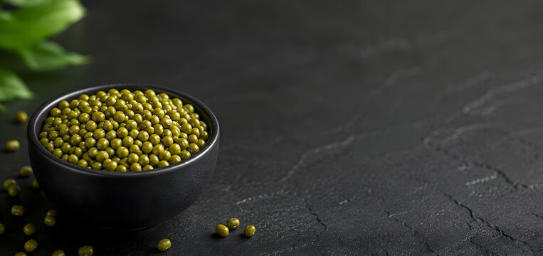 Green Mung Beans in Black Bowl on Dark Textured Background with Copy Space