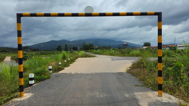 Rural Road with Height Restriction Barrier, Entrance Gate in Countryside Landscape. Height limit barrier with 2.5m sign on a rural asphalt road.