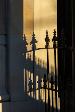 Shadow of wrought iron fence on brick column