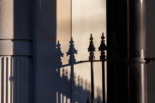 Shadow of wrought iron fence on brick column