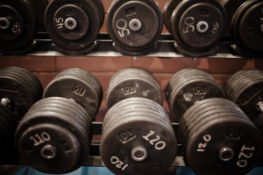 Close up of heavy dumbbells on a rack in a gym