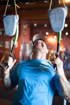 Smiling man trains grip strength on climbing holds