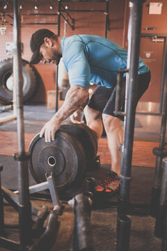 Strong man loading heavy weights onto bar