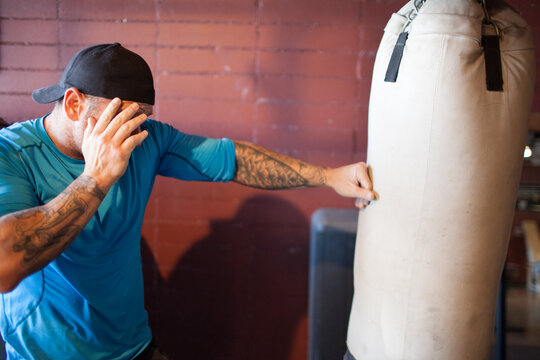 Tattooed man training with a punching bag