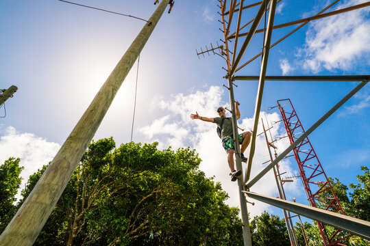 Adventurous man climbing up a communication tower