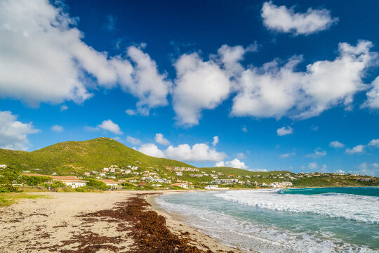 Scenic beach view with green hills and blue sky