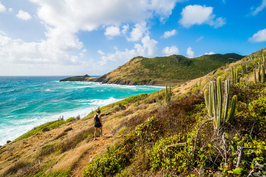 Woman hiking on a rugged tropical coastal path