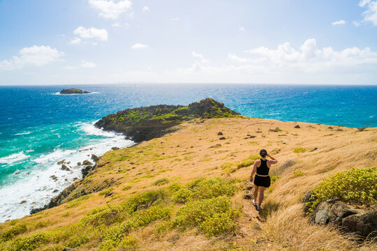 Woman hiking down a beautiful coastal path
