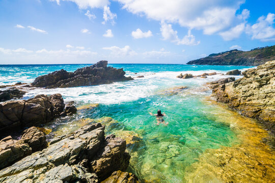 Woman swimming in a natural rock pool by the sea