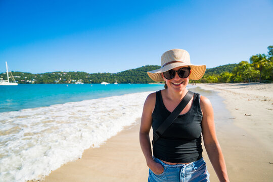 Happy woman in a sun hat enjoying a beach walk