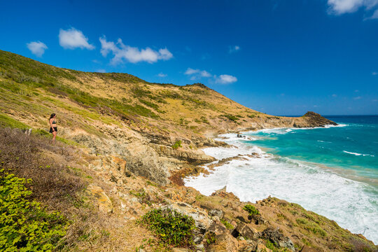 Woman hiking on a cliff overlooking the ocean