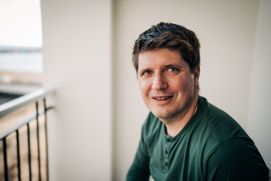 Mature man smiling looking at camera on balcony