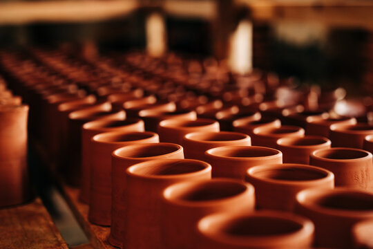 Rows of handcrafted terracotta pottery cups in workshop