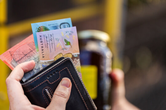 Australian person getting cash from wallet to purchase honey from roadside stall