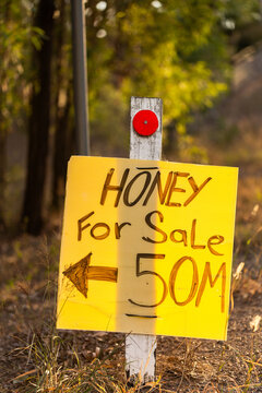 local honey for sale sign with arrow to roadside stall in Australia