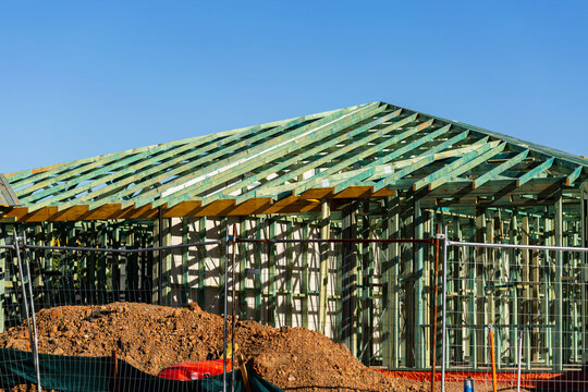 wooden frame structure of house under construction during housing crisis