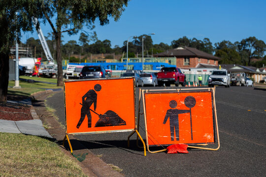 roadwork ahead sign with building construction site in background