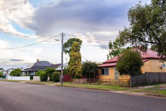 Dramatic clouds in sky with above houses along residential road in country town of Singleton