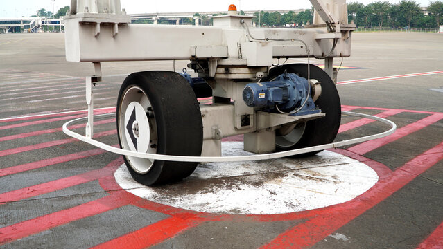Close Up Detail View of Heavy Duty Airport Jet Bridge Support Wheel and Motorized Drive Mechanism, Essential Ground Support Equipment for Safe Maneuvering and Positioning of Aircraft Boarding Bridges