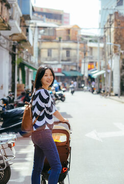 Rear view of a young Asian female tourist walking and exploring the historic Chikan Old Street in Zhanjiang, Guangdong, China
