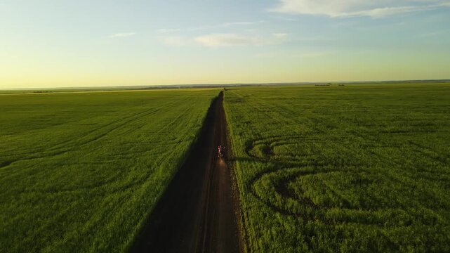 A motorcycle rides through green fields