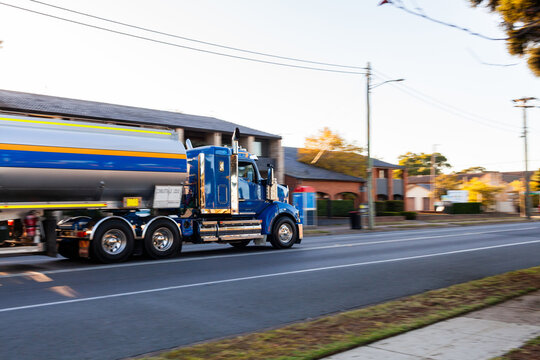 Panning image of truck driving past on country town road in sunrise light