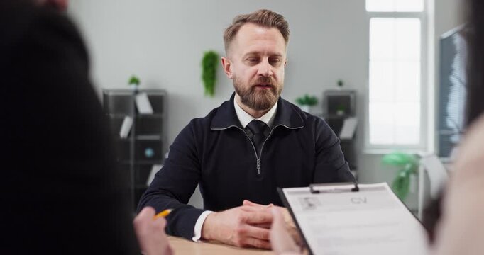 Interview candidate presents resume to HR recruiters. Focused hiring meeting highlights assessment, experience, and communication in a bright modern office. Clear concept of recruitment and hiring.