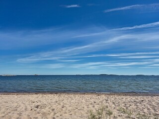 Obraz premium Vast beautiful seascape featuring a sandy shoreline and a clear blue sky with light clouds.