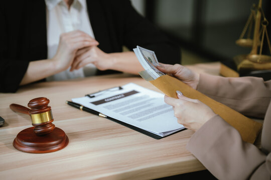 Close-up of a legal consultation involving a contract and cash payment, illustrating financial settlement, legal services, business negotiation, and compliance discussions.